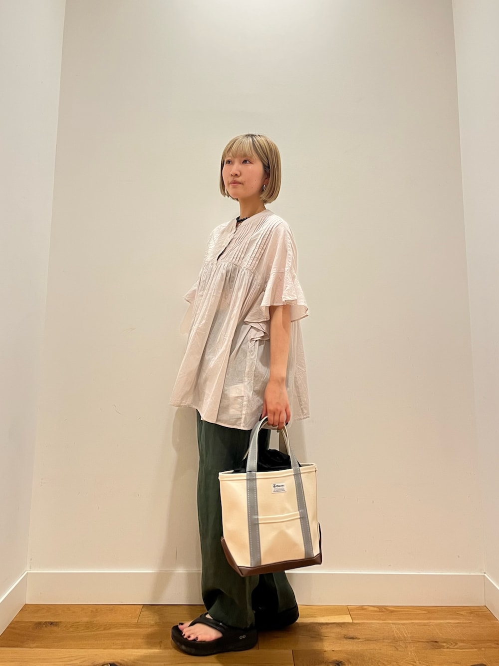 グレー系のシャツ/ブラウス、グリーン系のその他パンツ、グリーン系のトートバッグを着用したレディースの夏コーディネートの2枚目の写真