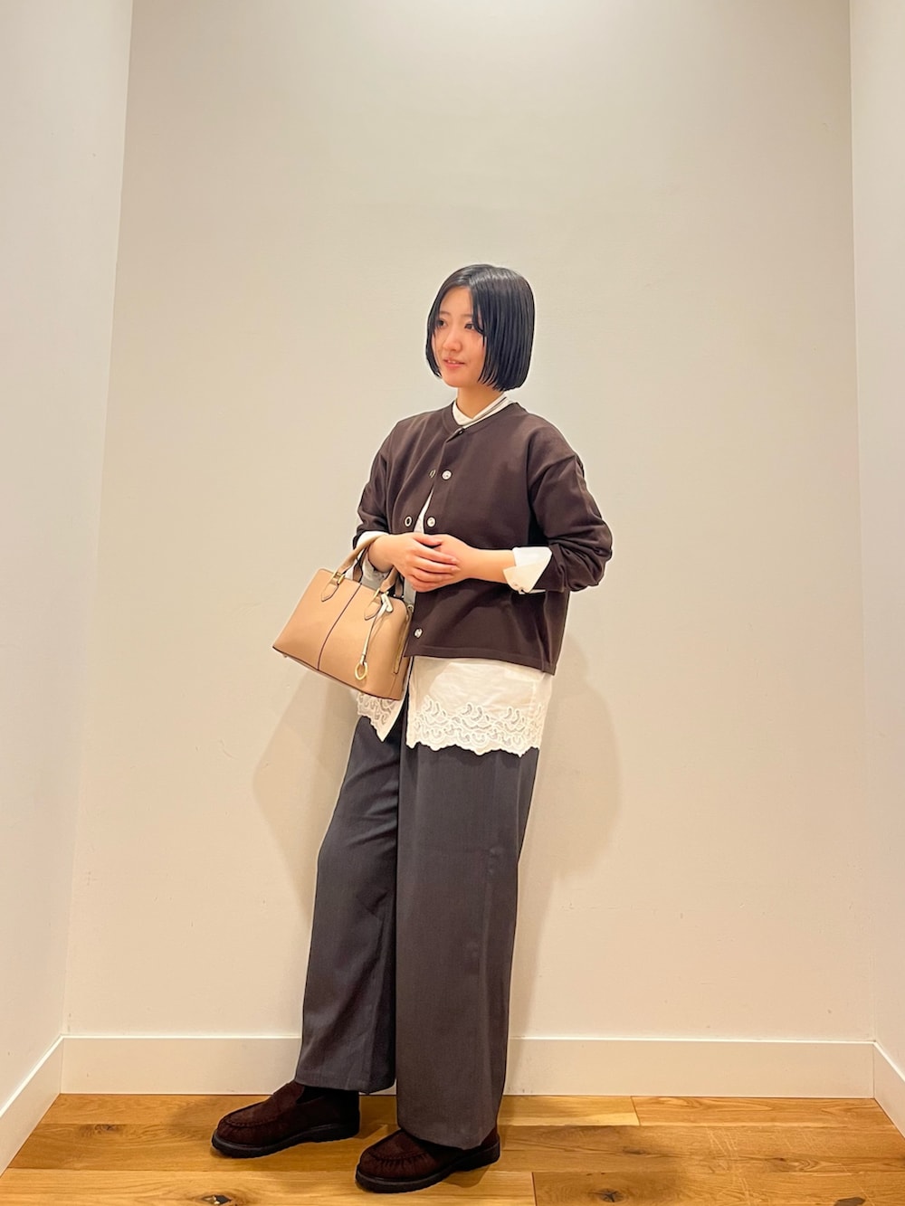 ブラウン系のカーディガン/ボレロ、ホワイト系のシャツ/ブラウス、グレー系のその他パンツを着用したレディースの秋コーディネートの2枚目の写真