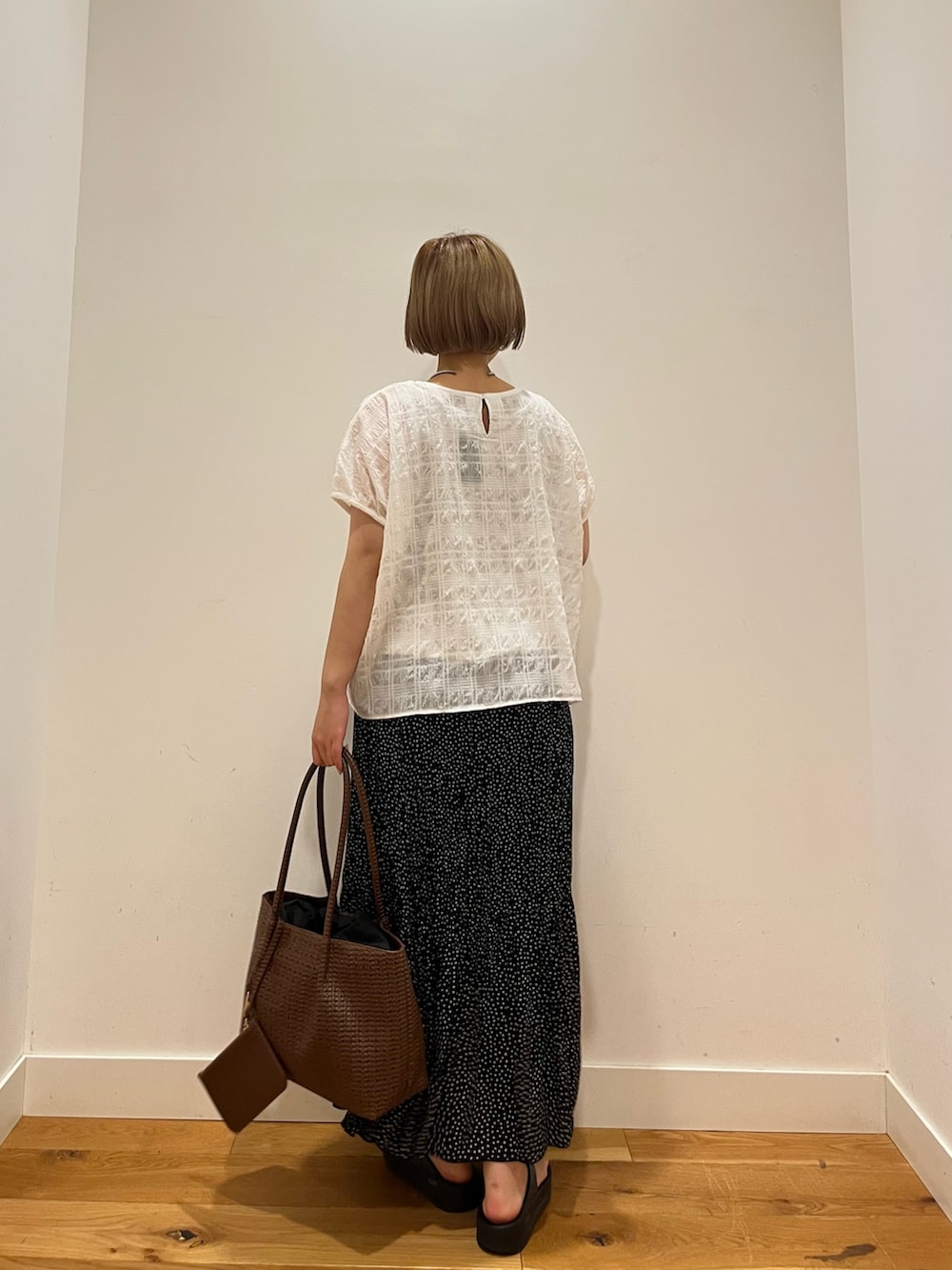 ホワイト系のシャツ/ブラウス、ブラック系のスカートを着用したレディースの夏コーディネートの3枚目の写真