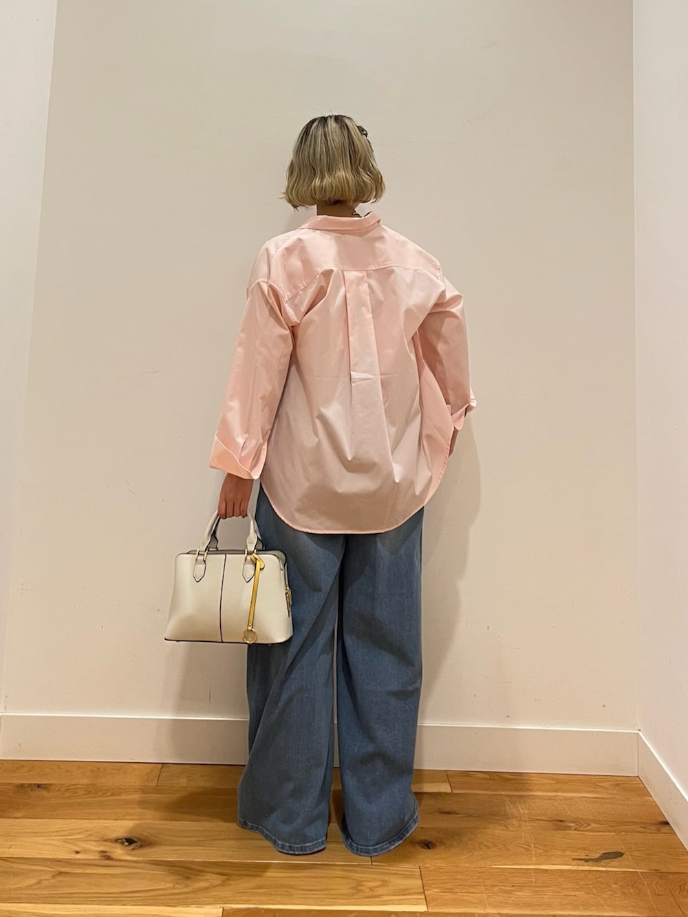 ピンク系のシャツ/ブラウス、ブルー系のデニムパンツを着用したレディースの春コーディネートの3枚目の写真