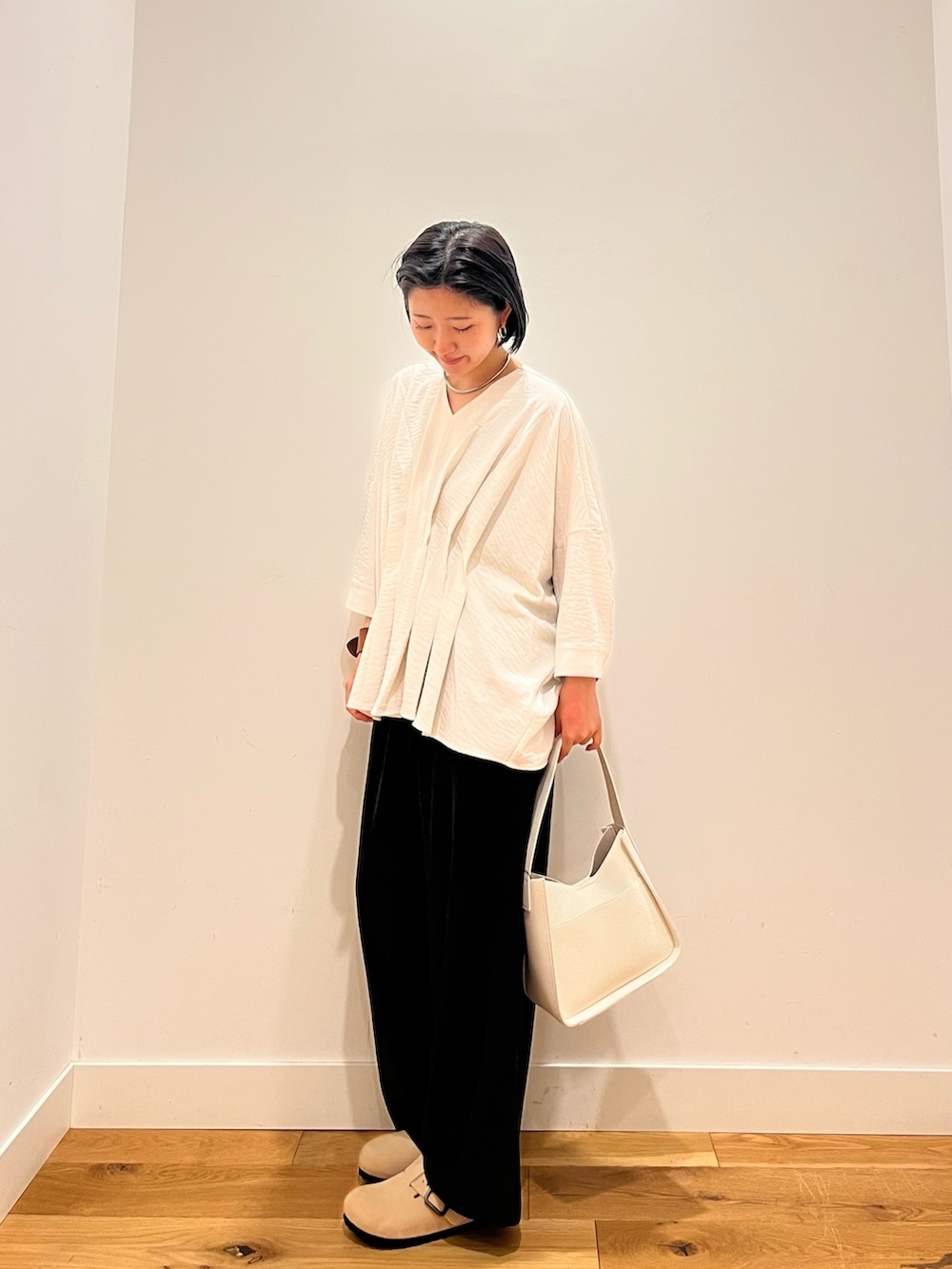 ブラック系のその他パンツ、ホワイト系のシャツ/ブラウス、ホワイト系のハンドバッグを着用したレディースの秋コーディネートの2枚目の写真