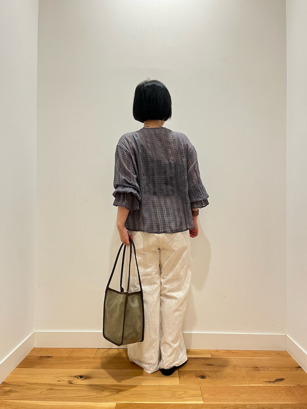 ブルー系のシャツ/ブラウス、ホワイト系のその他パンツ、グリーン系のトートバッグを着用したレディースの秋コーディネートの3枚目の写真