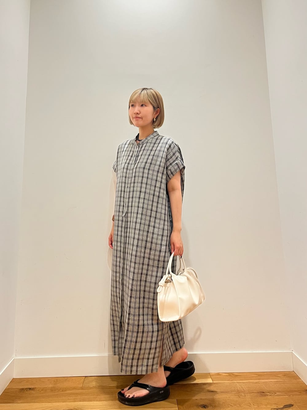 グレー系のワンピース、ブルー系のネックレスを着用したレディースの夏コーディネートの2枚目の写真