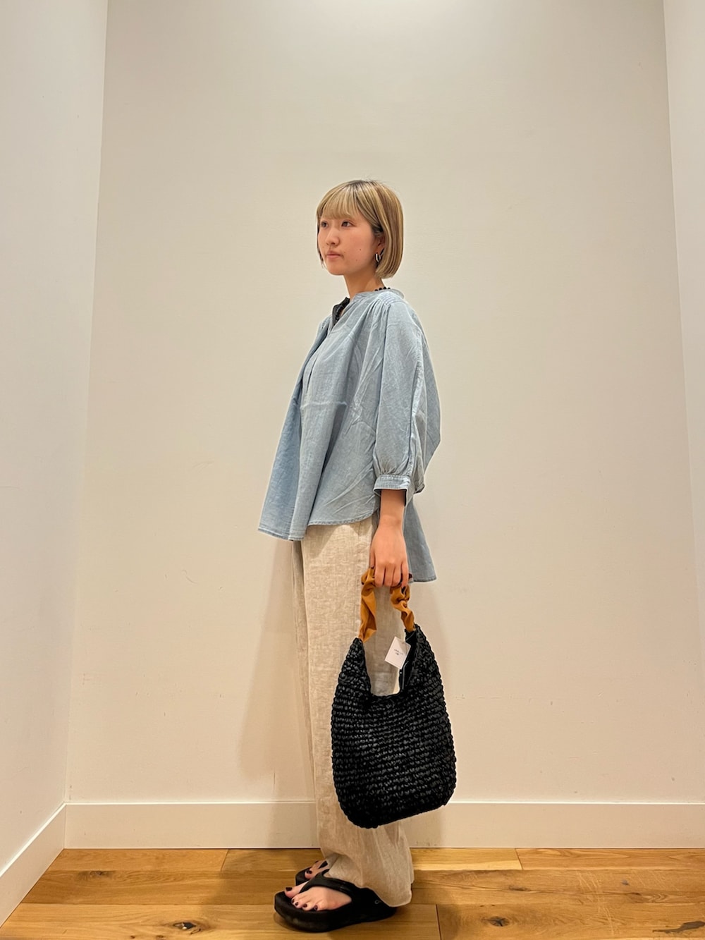 ベージュ系のその他パンツ、ブルー系のシャツ/ブラウス、オレンジ系のかごバッグを着用したレディースの夏コーディネートの3枚目の写真