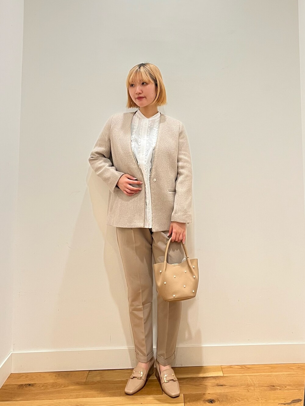 グレー系のスーツジャケット、ホワイト系のシャツ/ブラウス、ベージュ系のその他パンツを着用したレディースの冬コーディネートの2枚目の写真