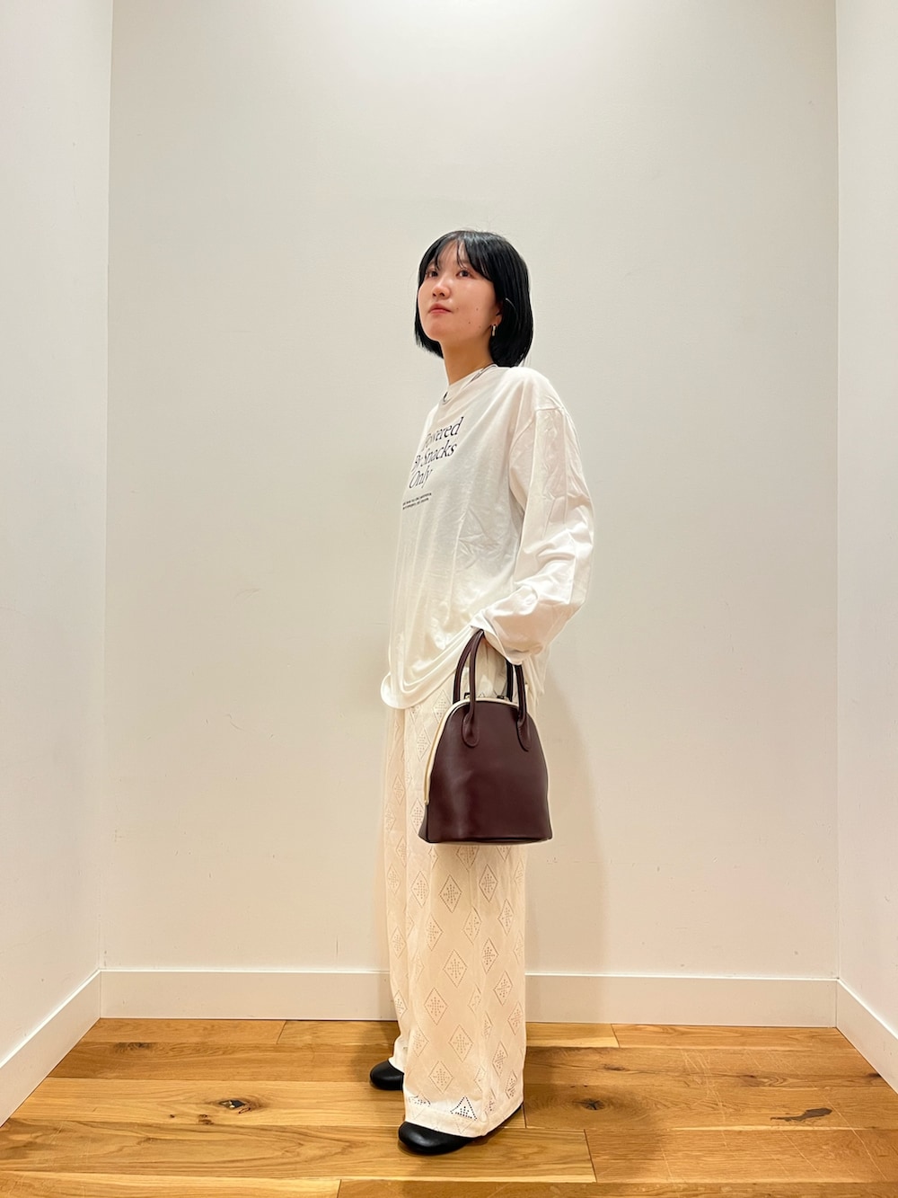 ホワイト系のTシャツ/カットソー、ホワイト系のその他パンツ、ブラック系のその他シューズを着用したレディースの秋コーディネートの2枚目の写真