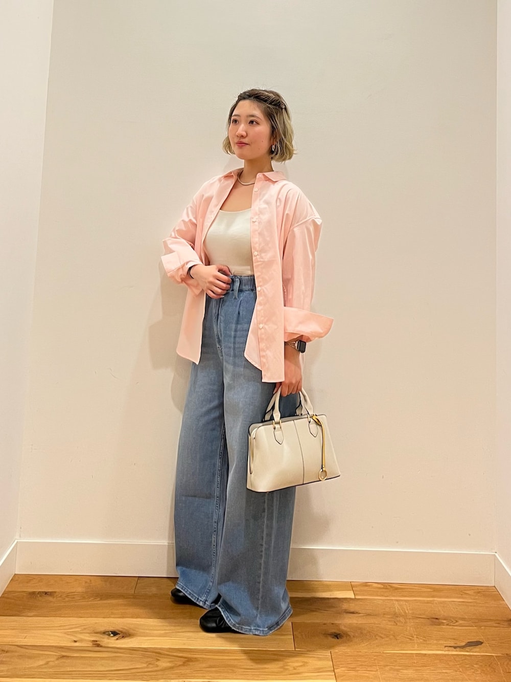 ピンク系のシャツ/ブラウス、ブルー系のデニムパンツを着用したレディースの春コーディネートの2枚目の写真