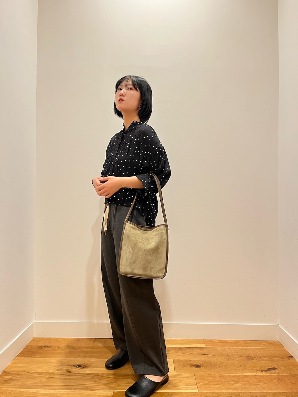 グレー系のその他パンツ、ブラック系のシャツ/ブラウス、グリーン系のトートバッグを着用したレディースの秋コーディネートの2枚目の写真
