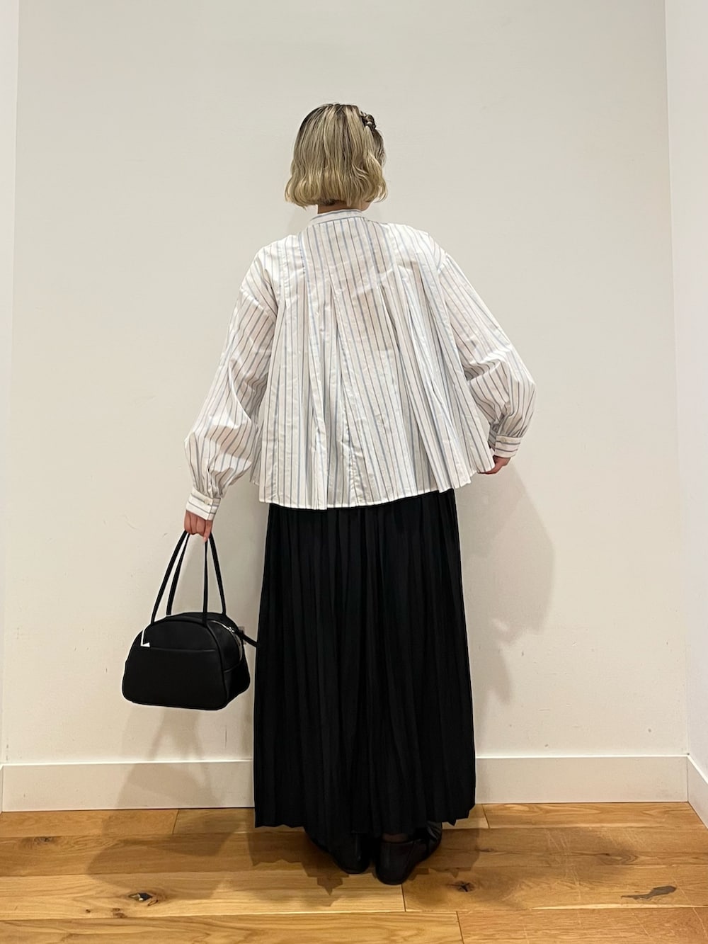 ブラック系のスカート、ホワイト系のシャツ/ブラウスを着用したレディースの春コーディネートの3枚目の写真