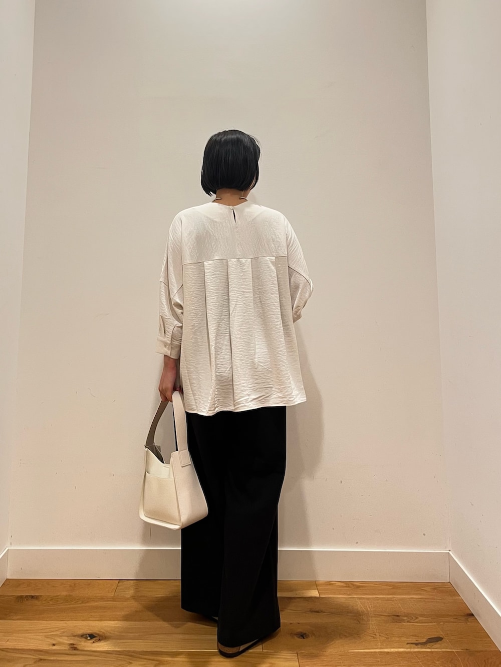 ブラック系のその他パンツ、ホワイト系のシャツ/ブラウス、ホワイト系のハンドバッグを着用したレディースの秋コーディネートの3枚目の写真