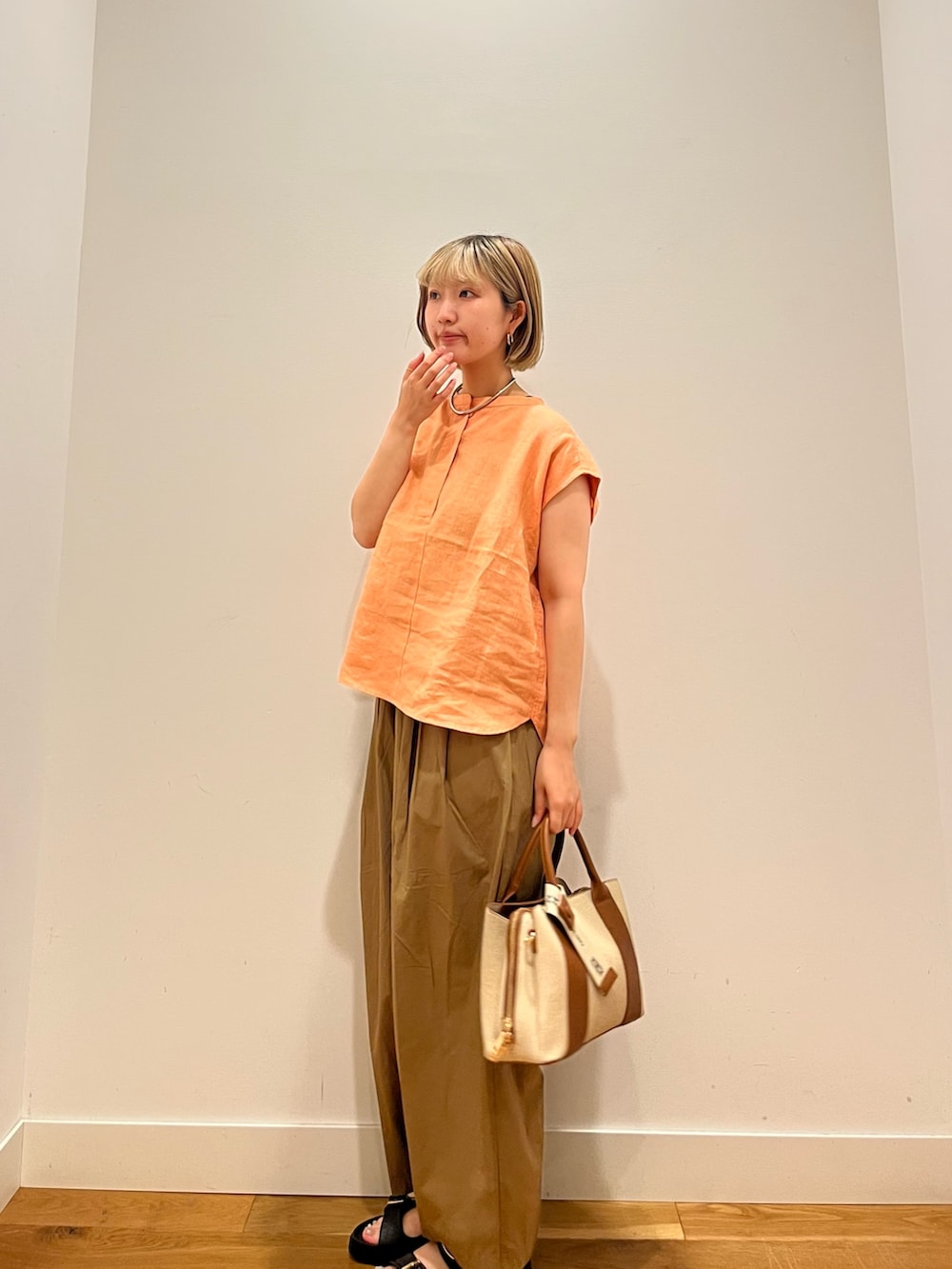 ベージュ系のその他パンツ、オレンジ系のシャツ/ブラウス、ブラック系のサンダルを着用したレディースの夏コーディネートの2枚目の写真
