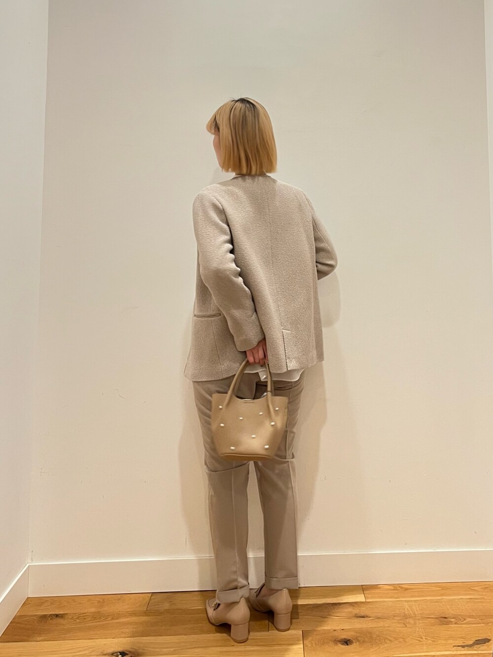 グレー系のスーツジャケット、ホワイト系のシャツ/ブラウス、ベージュ系のその他パンツを着用したレディースの冬コーディネートの3枚目の写真