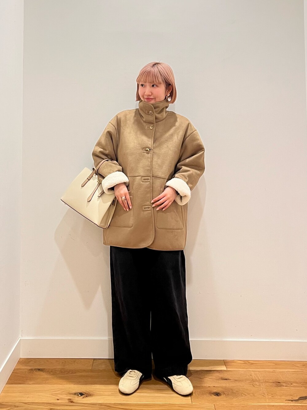 ホワイト系のムートンコート、ベージュ系のスニーカーを着用したレディースの冬コーディネートの6枚目の写真
