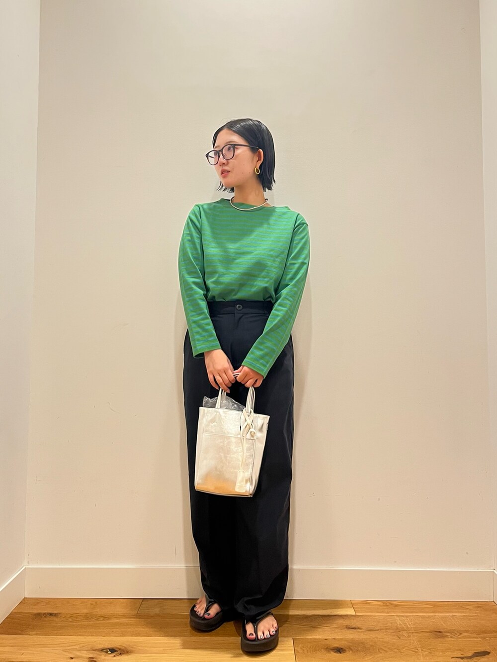 グリーン系のTシャツ/カットソー、ブルー系のその他パンツ、ブラック系のハンドバッグを着用したレディースの秋コーディネートの3枚目の写真