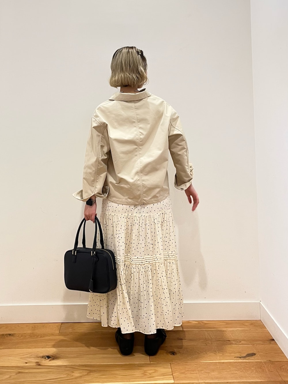 ホワイト系のスカート、ホワイト系のカバーオールを着用したレディースの春コーディネートの3枚目の写真