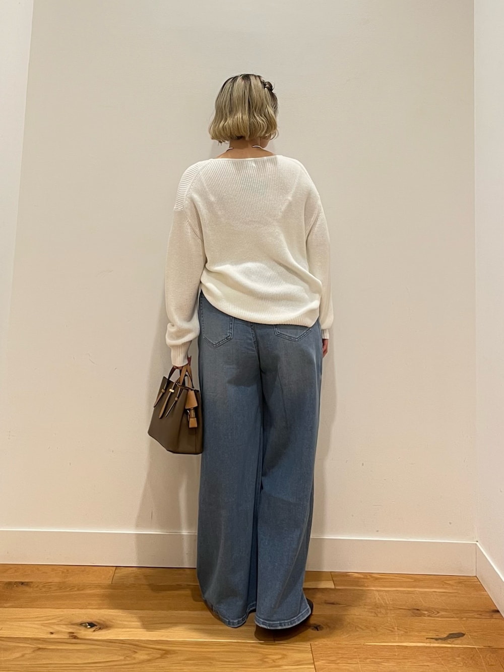 ブルー系のデニムパンツ、ホワイト系のニット/セーターを着用したレディースの春コーディネートの3枚目の写真