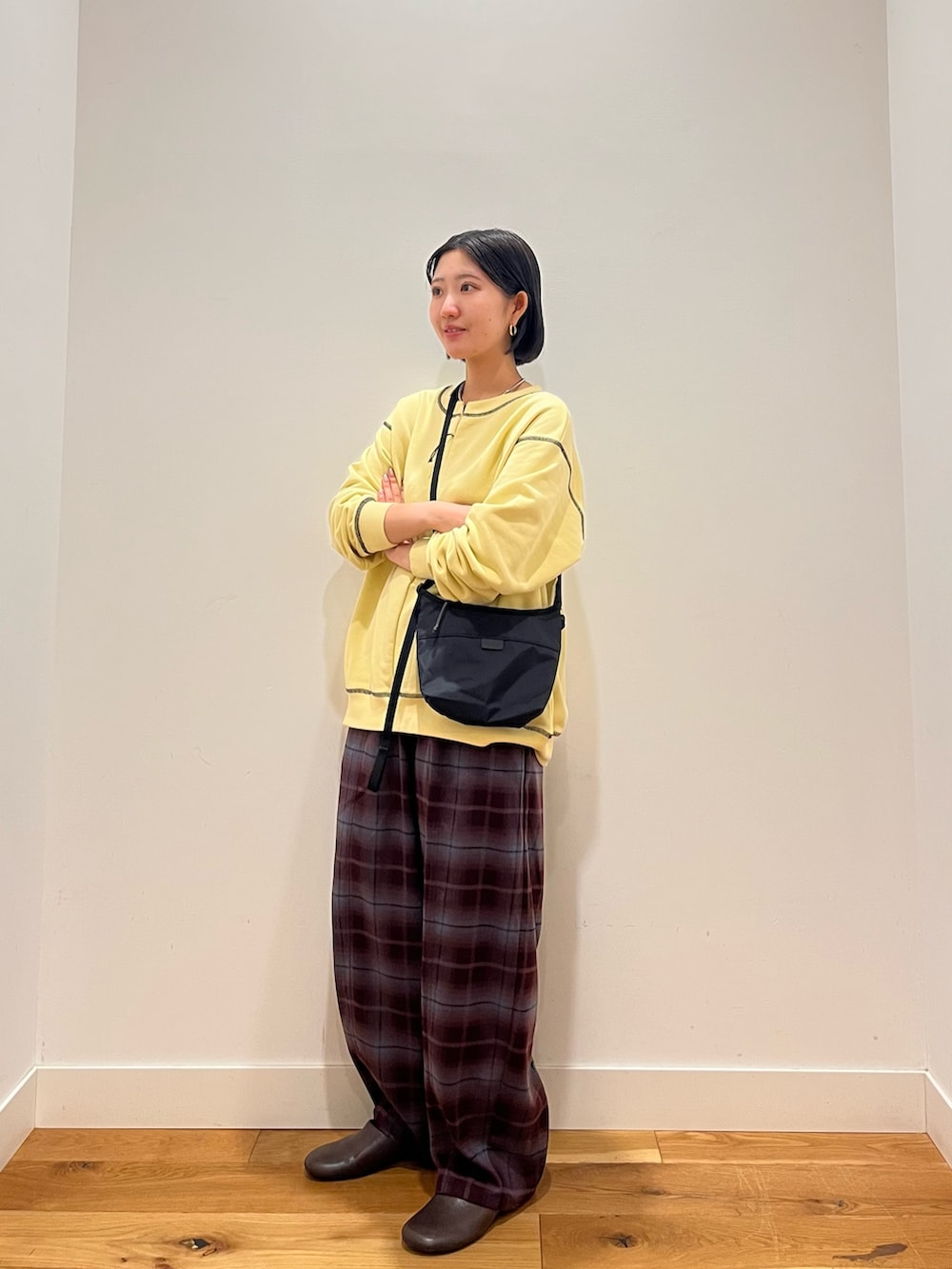 イエロー系のスウェット、パープル系のその他パンツ、ブラック系のショルダーバッグを着用したレディースの秋コーディネートの2枚目の写真
