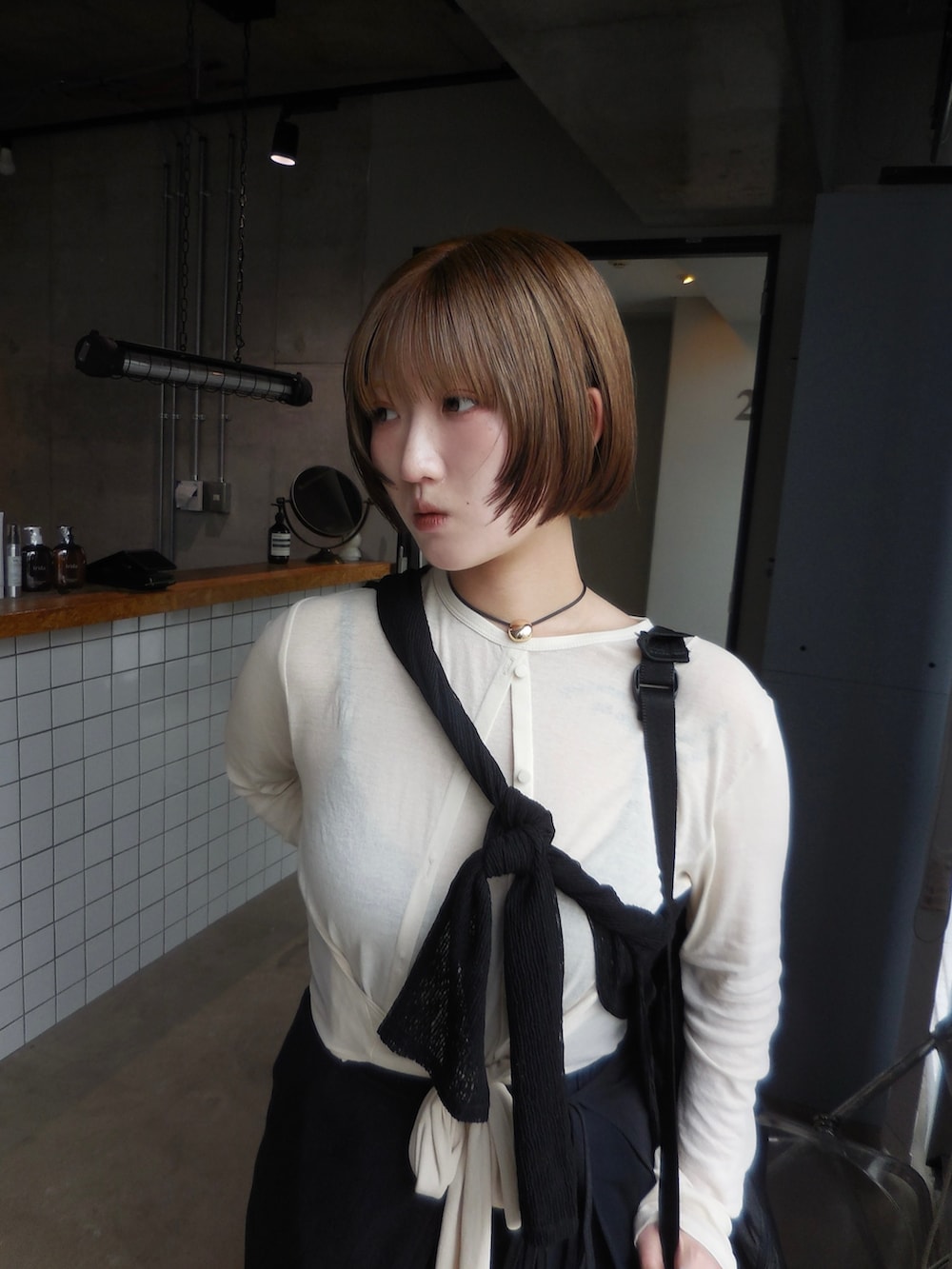 ホワイト系のトップス、ブラック系のパンツを着用したレディースの秋コーディネートの2枚目の写真