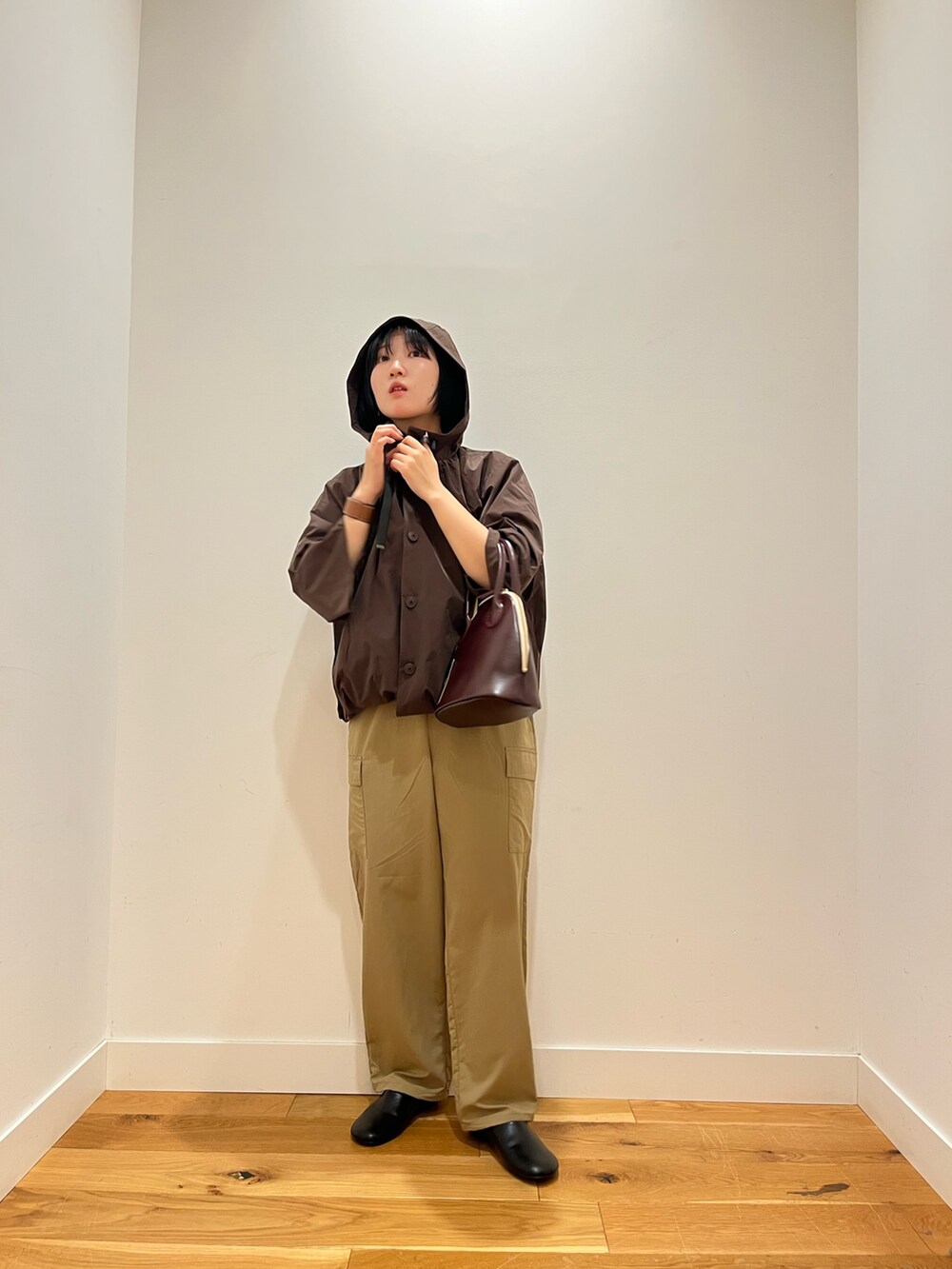 ブラウン系のその他アウター、ベージュ系のその他パンツ、レッド系のハンドバッグを着用したレディースの秋コーディネートの4枚目の写真