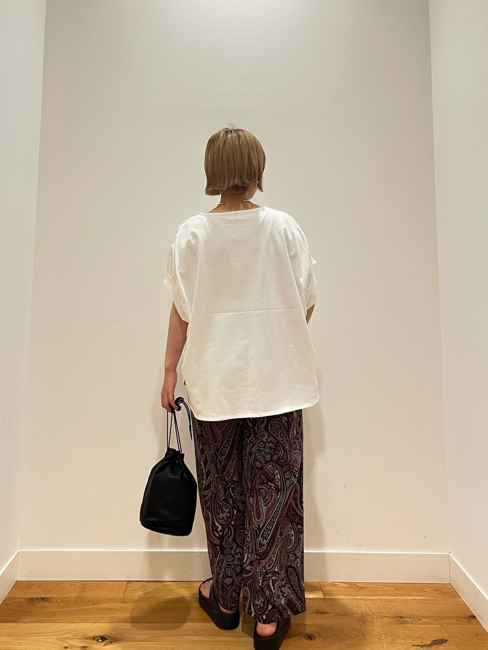 ホワイト系のTシャツ/カットソー、レッド系のその他パンツ、ブラック系のショルダーバッグを着用したレディースの夏コーディネートの3枚目の写真