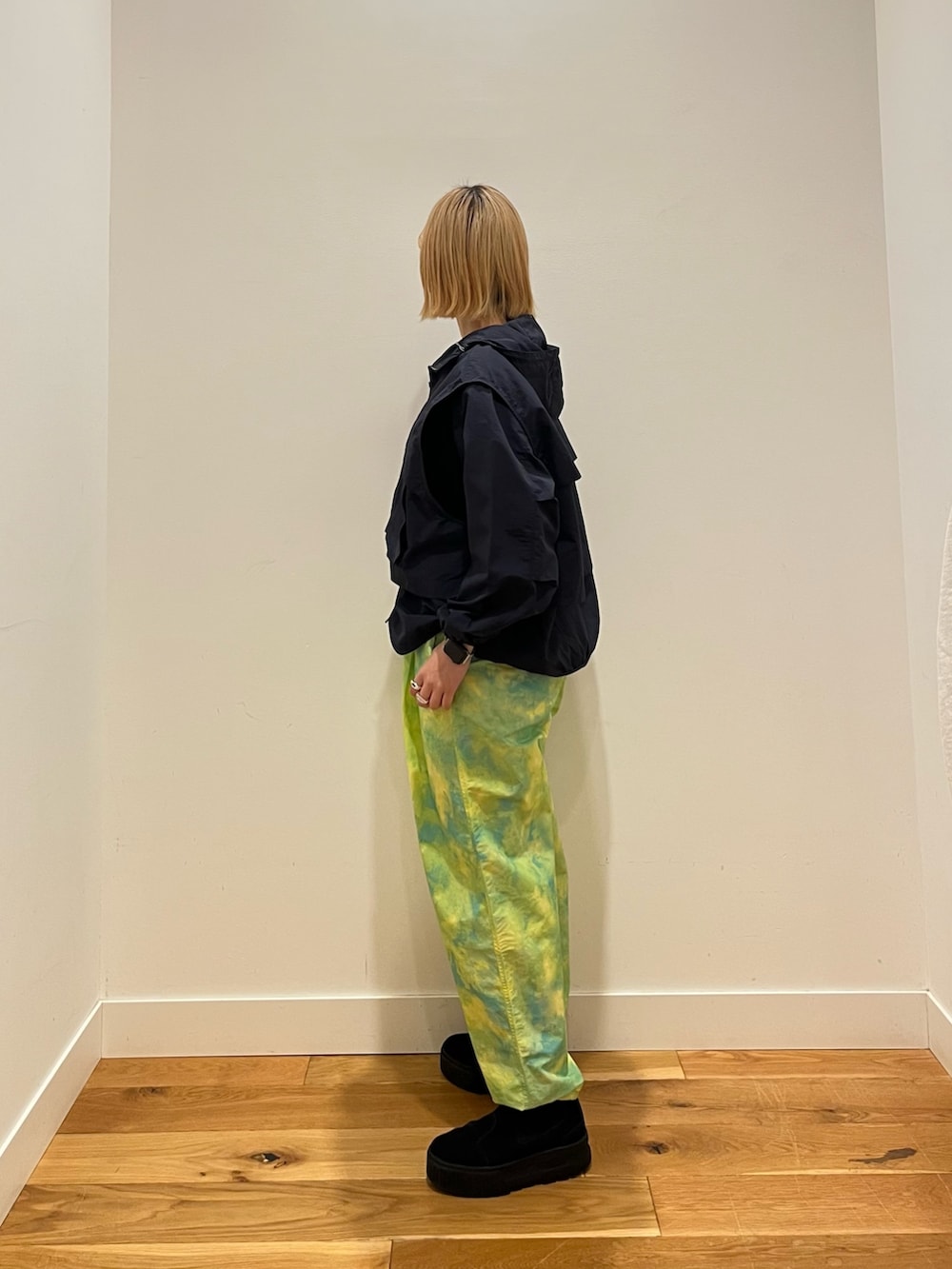 グレー系のベスト、ブルー系のナイロンジャケット、グリーン系のその他パンツを着用したレディースの冬コーディネートの3枚目の写真