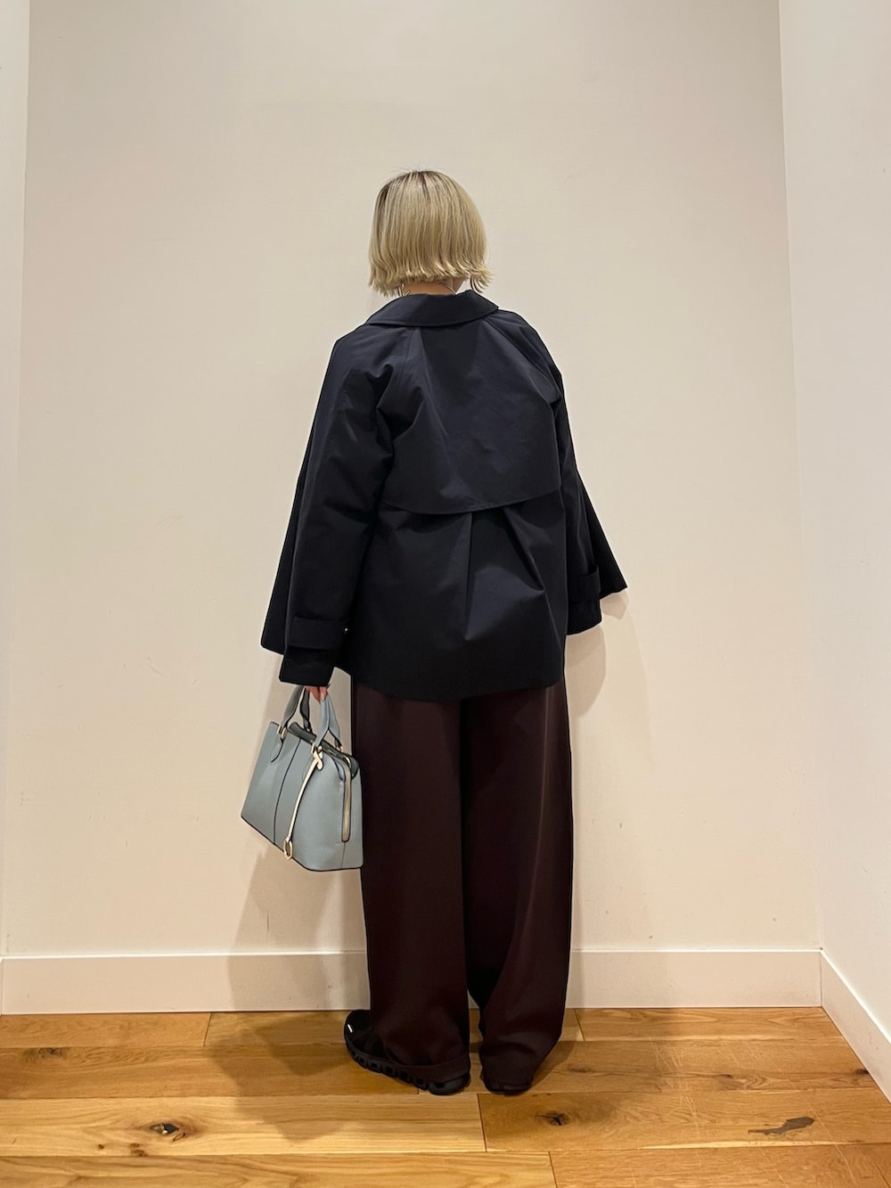 ブルー系のトレンチコート、ブルー系のTシャツ/カットソー、ブラウン系のその他パンツを着用したレディースの春コーディネートの3枚目の写真