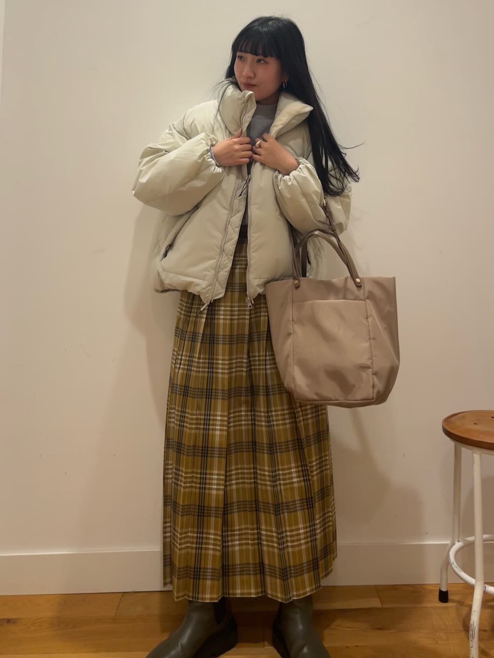 ホワイト系のダウンジャケット/コート、イエロー系のスカート、ベージュ系のバッグを着用したレディースの秋コーディネートの2枚目の写真