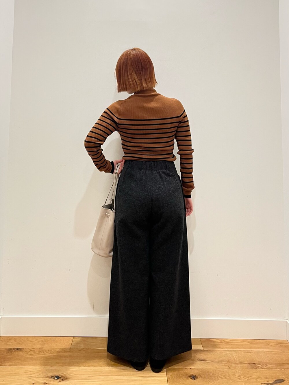 ブラウン系のニット/セーター、グレー系のその他パンツ、グレー系のショルダーバッグを着用したレディースの冬コーディネートの3枚目の写真