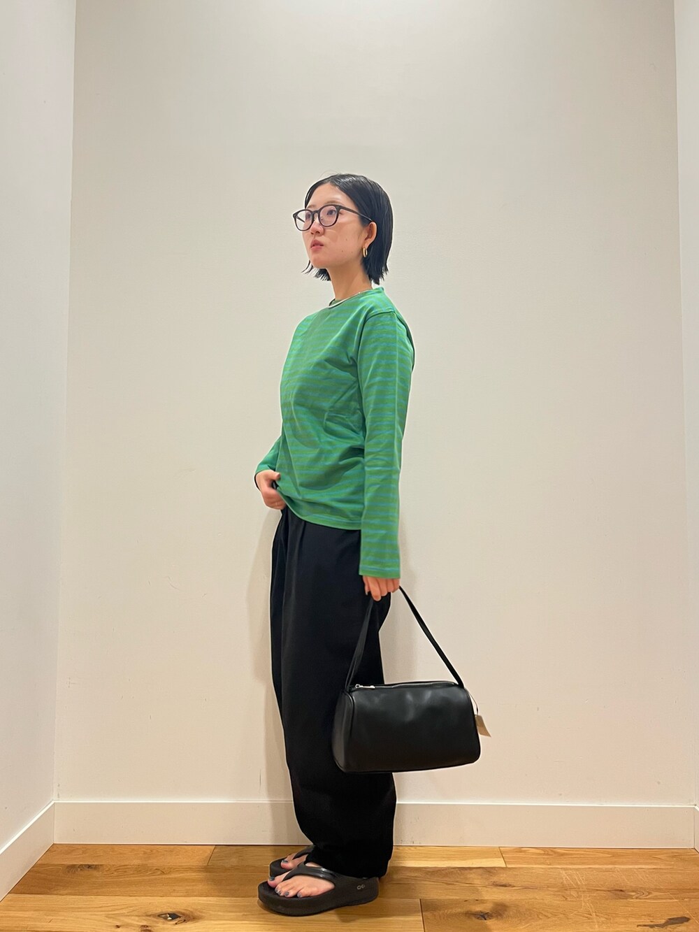 グリーン系のTシャツ/カットソー、ブルー系のその他パンツ、ブラック系のハンドバッグを着用したレディースの秋コーディネートの2枚目の写真