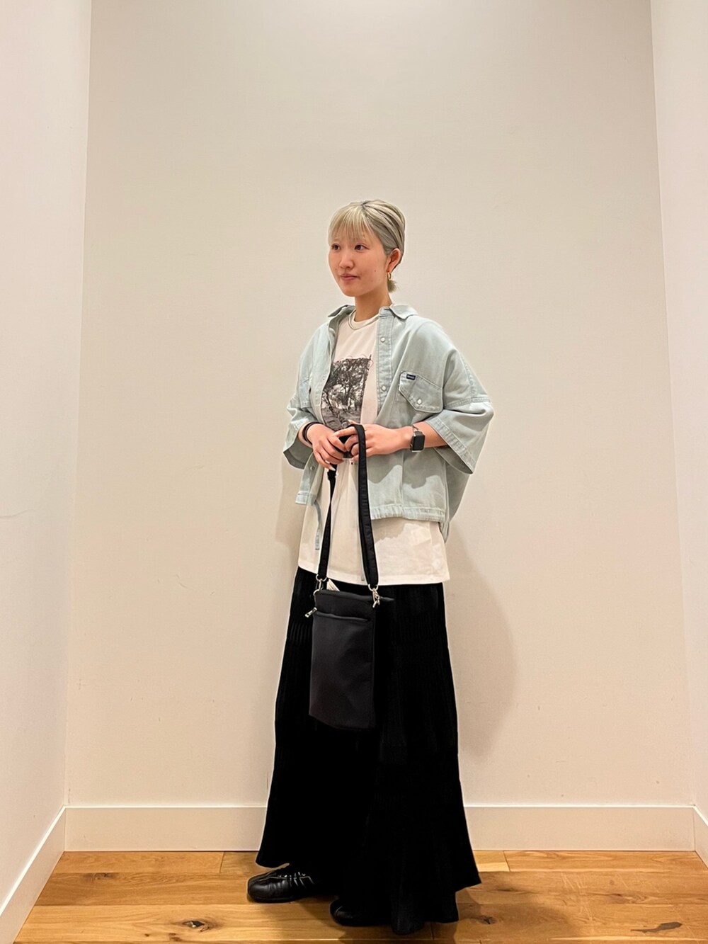 ホワイト系のTシャツ/カットソー、ブルー系のシャツ/ブラウス、ブラック系のスカートを着用したレディースの春コーディネートの2枚目の写真