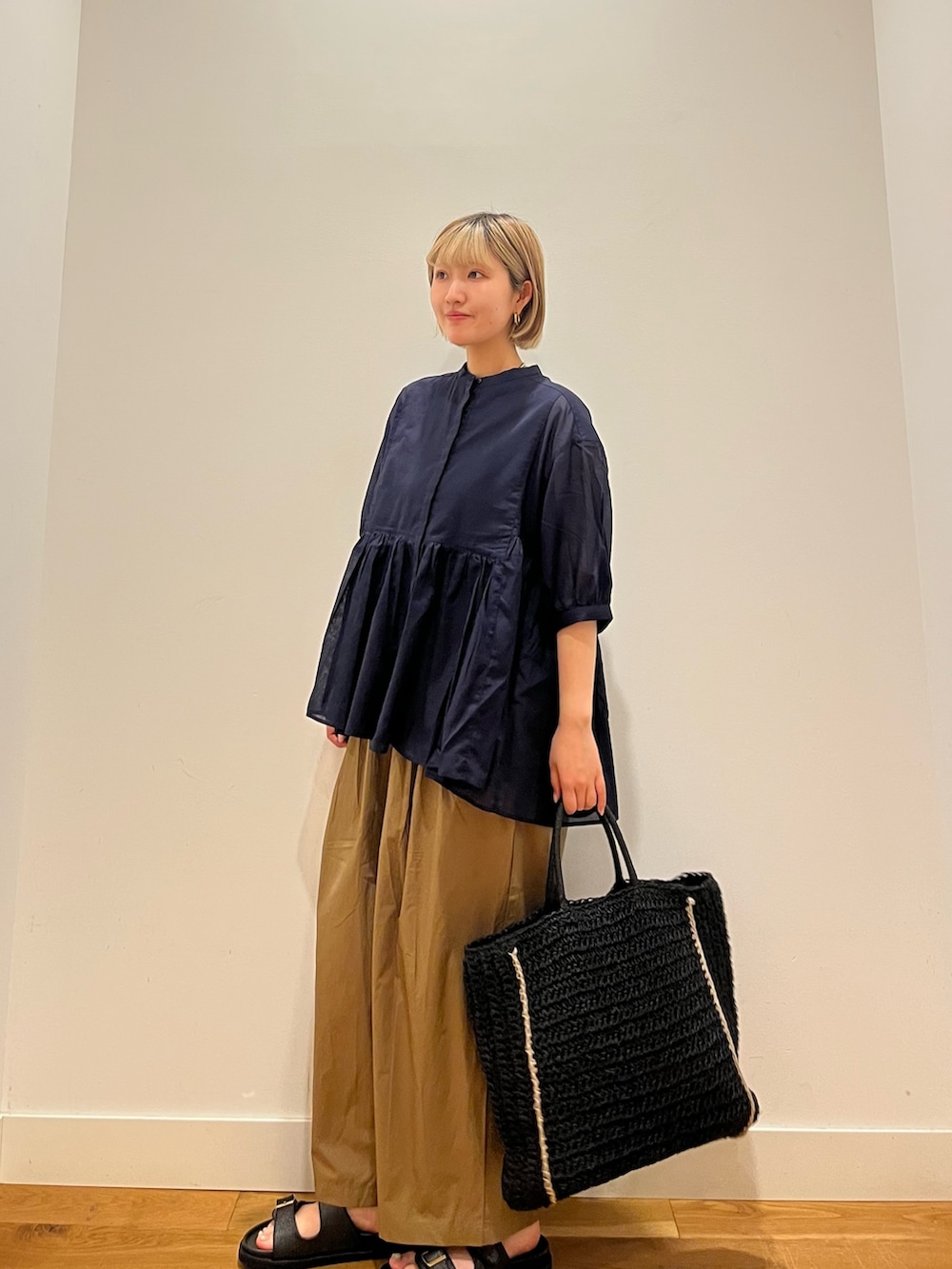 ブルー系のシャツ/ブラウス、ベージュ系のその他パンツ、ブラック系のトートバッグを着用したレディースの夏コーディネートの2枚目の写真