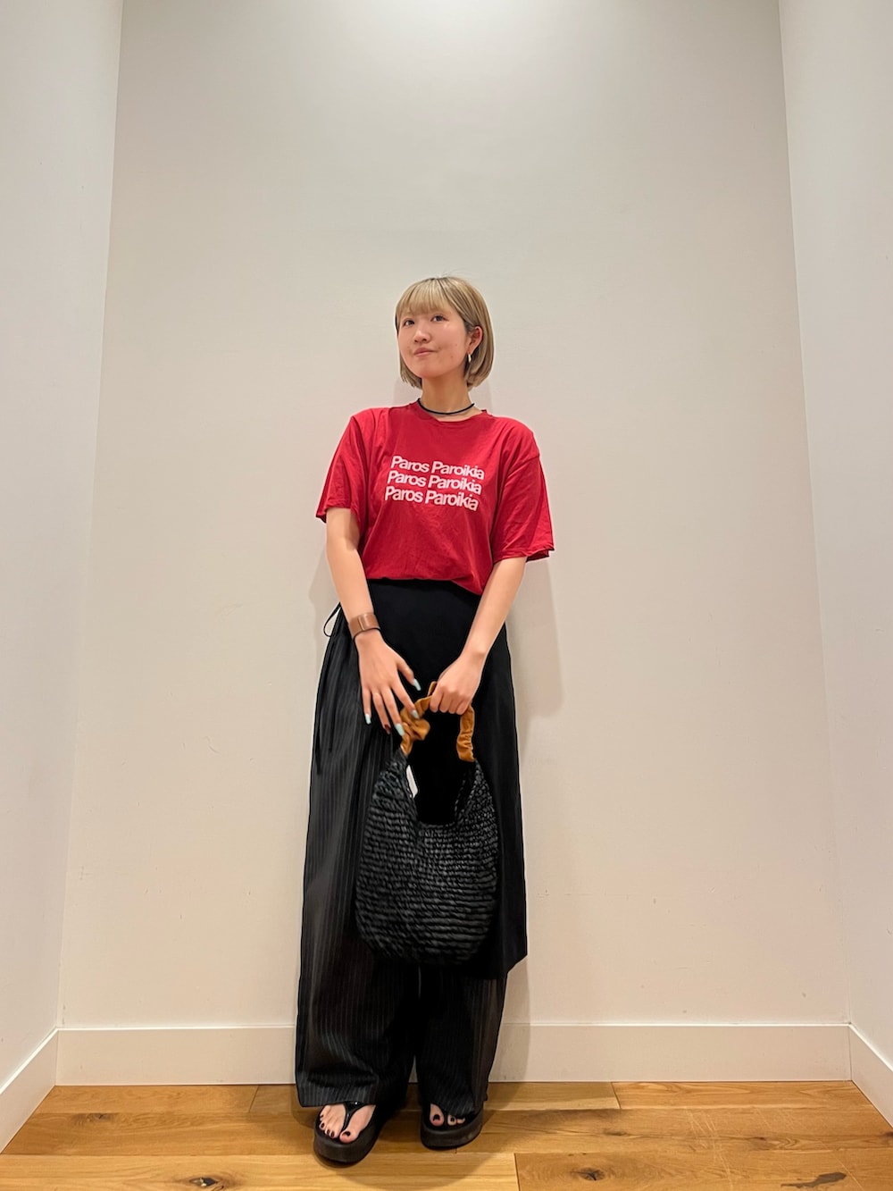 レッド系のTシャツ/カットソー、オレンジ系のかごバッグを着用したレディースの夏コーディネートの2枚目の写真