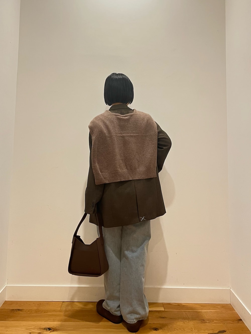 ブルー系のデニムパンツ、ブラウン系のその他アウター、ブルー系のTシャツ/カットソーを着用したレディースの秋コーディネートの3枚目の写真