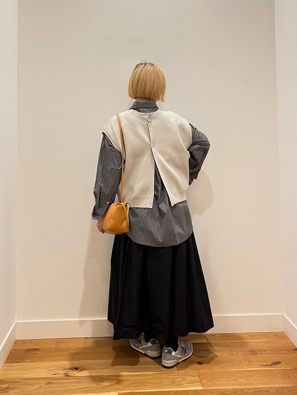 ブラック系のシャツ/ブラウス、グレー系のベスト、ブラック系のスカートを着用したレディースの冬コーディネートの3枚目の写真