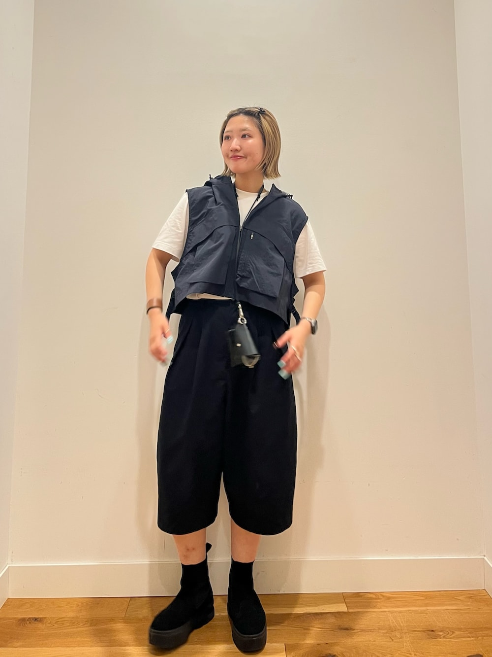 ブルー系のベスト、ブラック系のその他パンツを着用したレディースの夏コーディネートの2枚目の写真