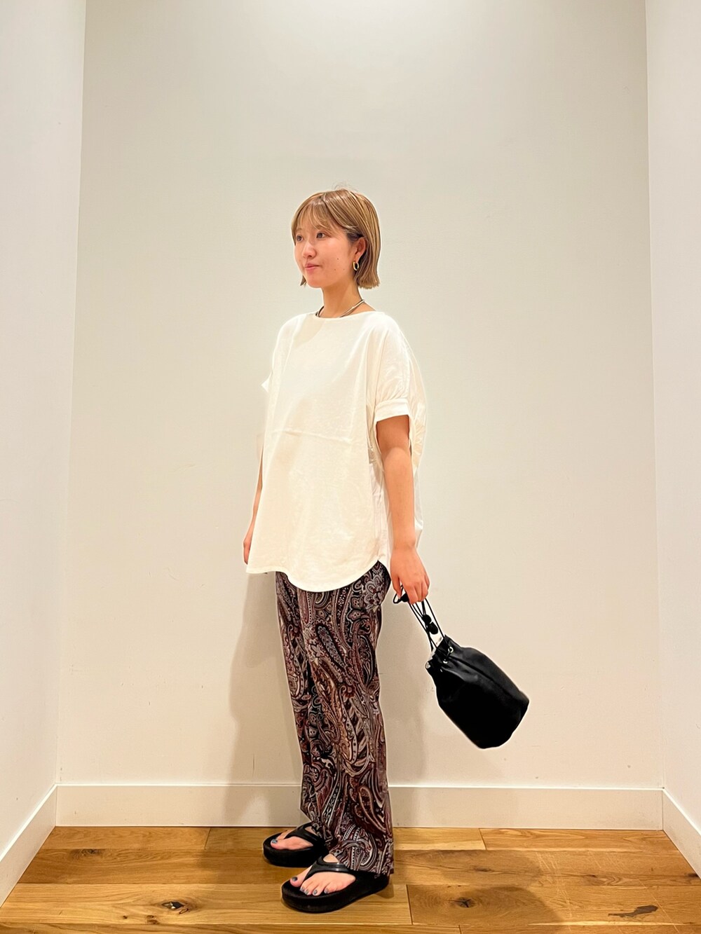 ホワイト系のTシャツ/カットソー、レッド系のその他パンツ、ブラック系のショルダーバッグを着用したレディースの夏コーディネートの2枚目の写真