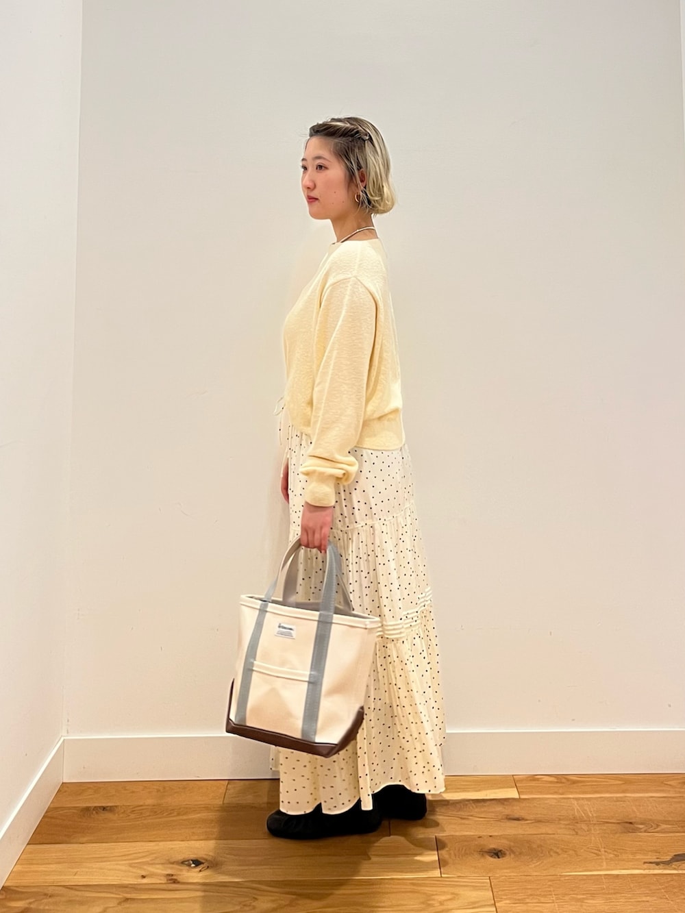 ホワイト系のスカート、ベージュ系のニット/セーターを着用したレディースの春コーディネートの3枚目の写真