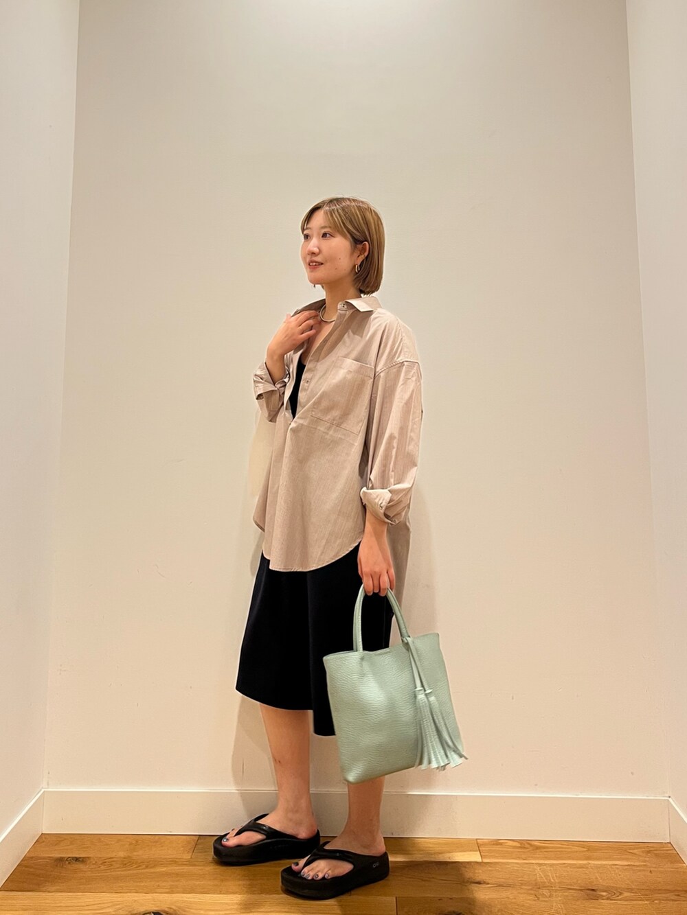 ベージュ系のシャツ/ブラウス、ブラック系のトップスを着用したレディースの夏コーディネートの2枚目の写真