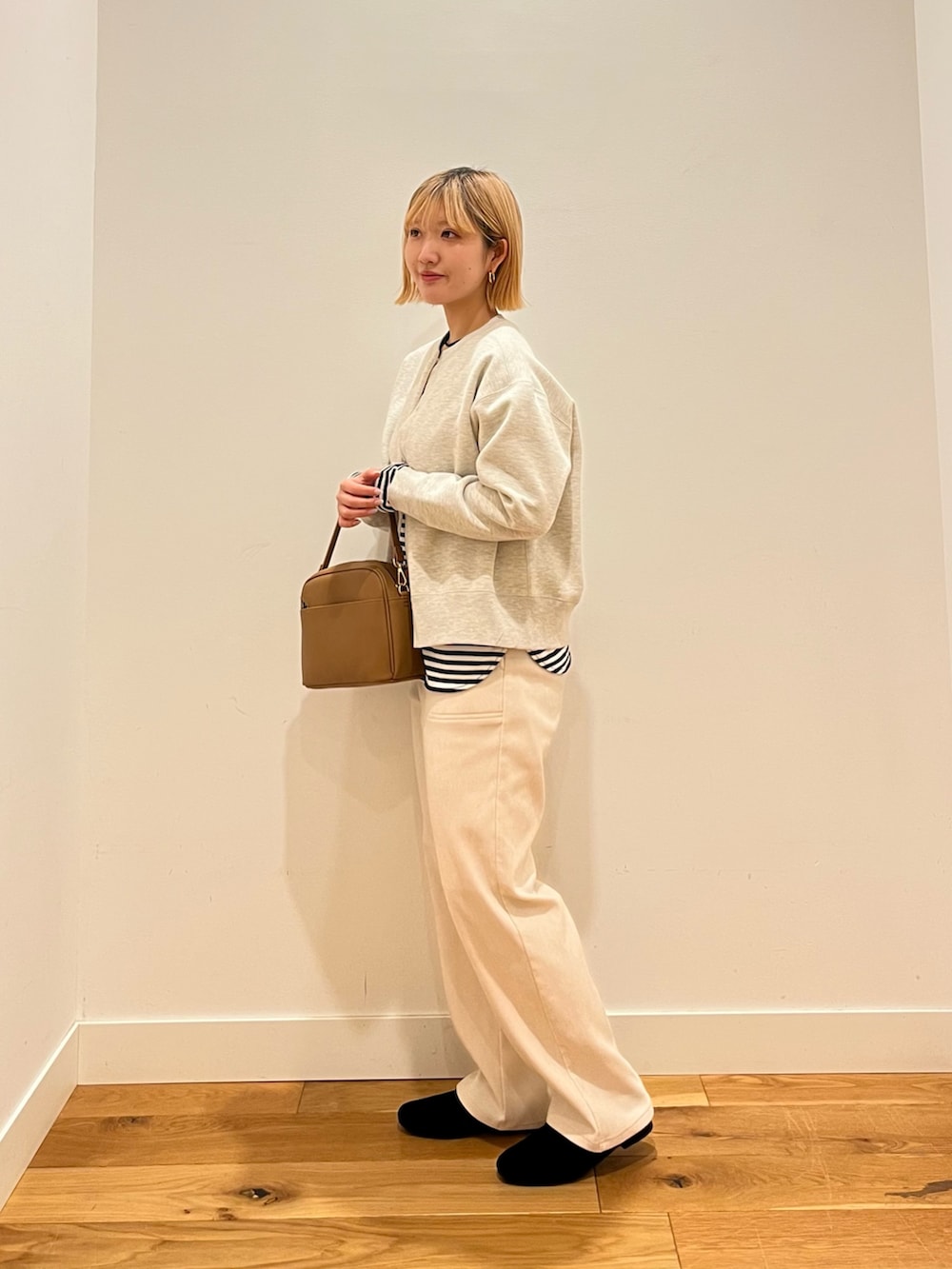 ベージュ系のカーディガン/ボレロ、ベージュ系のショルダーバッグ、ブラック系のローファーを着用したレディースの冬コーディネートの2枚目の写真