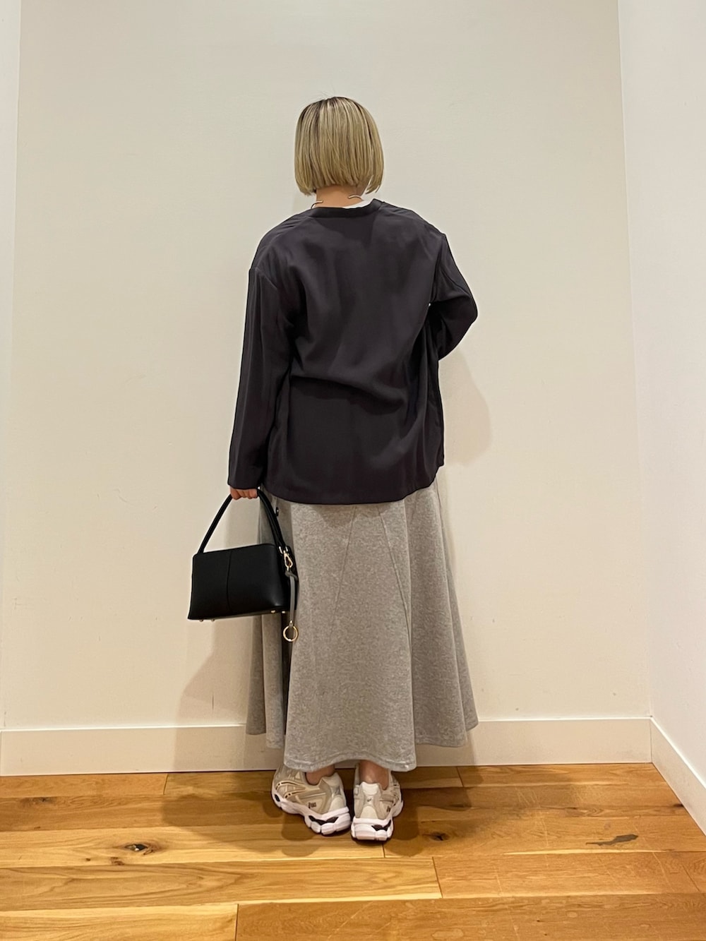 グレー系のスカートを着用したレディースの春コーディネートの3枚目の写真