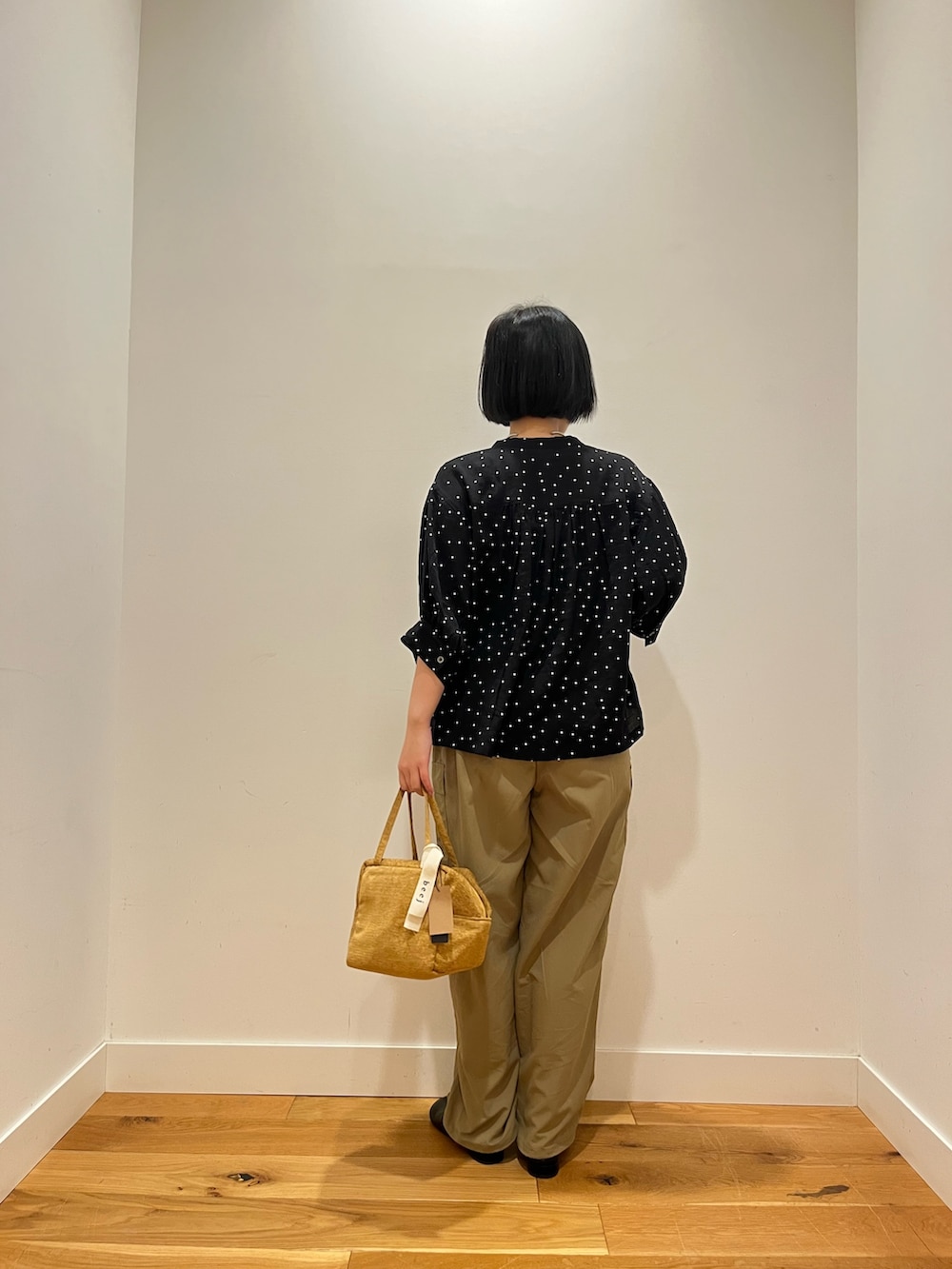 ブラック系のシャツ/ブラウス、ベージュ系のその他パンツ、グリーン系のハンドバッグを着用したレディースの秋コーディネートの2枚目の写真