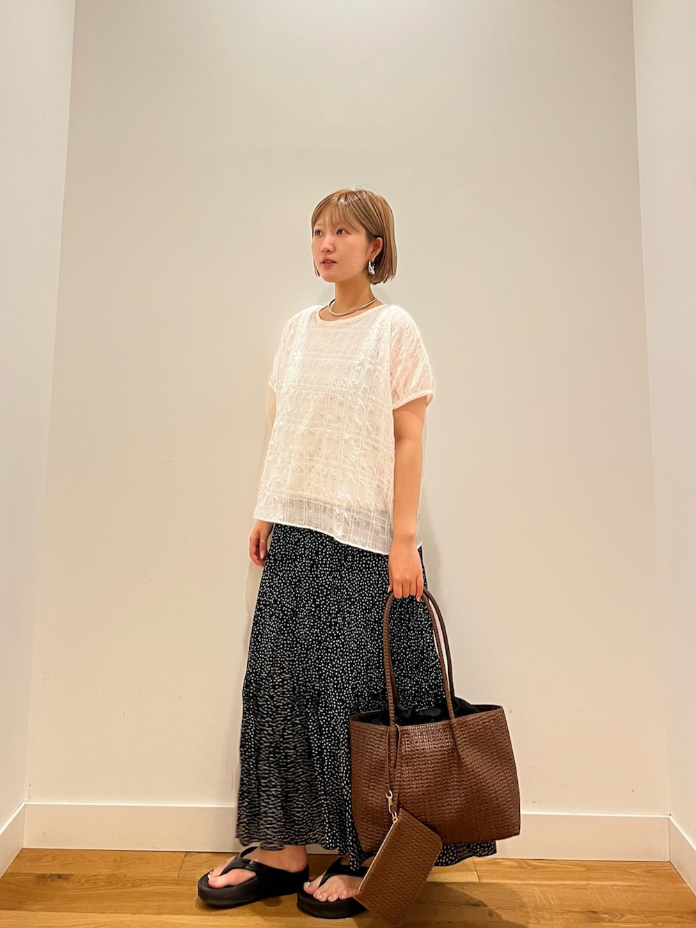 ホワイト系のシャツ/ブラウス、ブラック系のスカートを着用したレディースの夏コーディネートの2枚目の写真