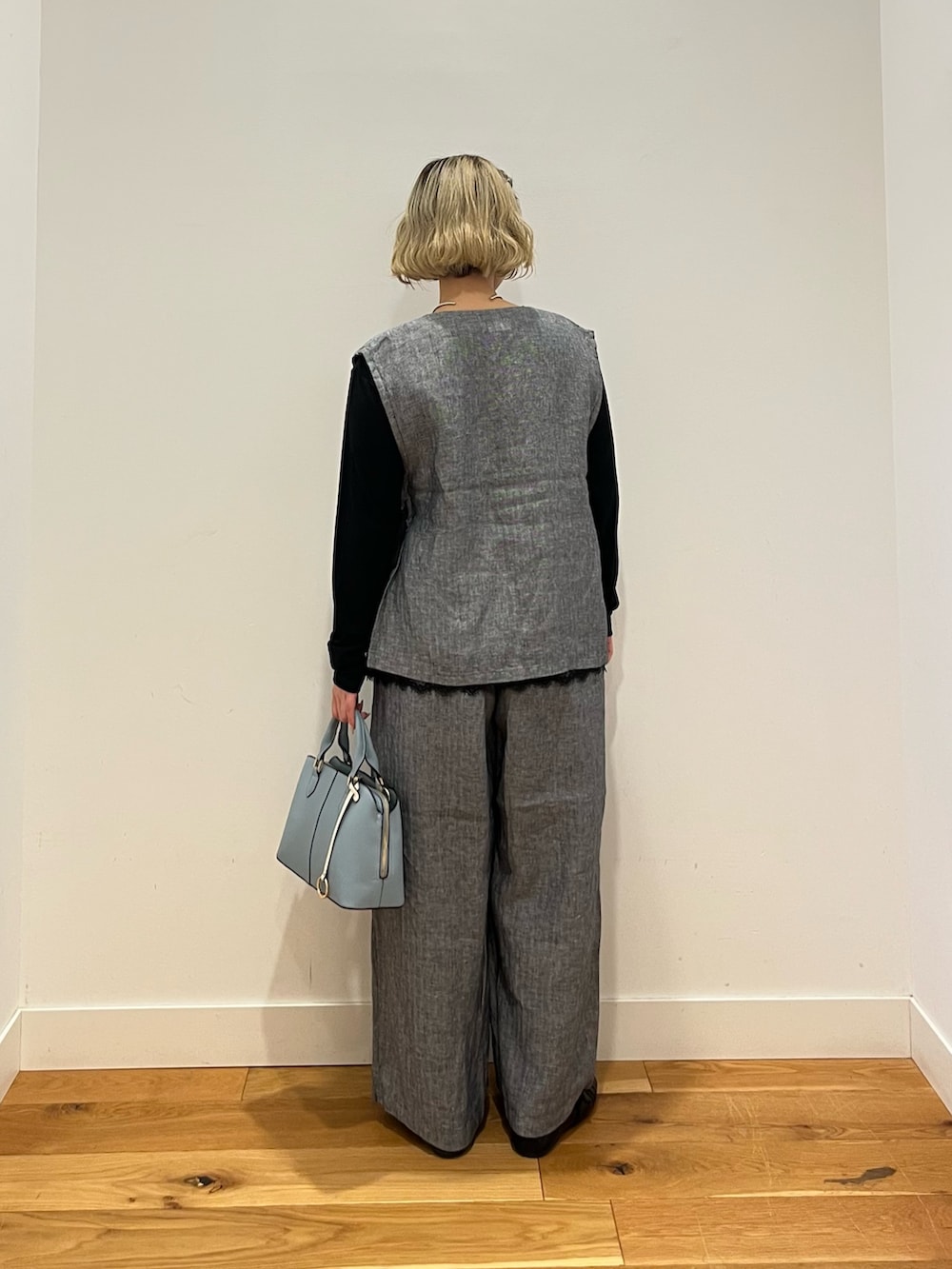 ブラック系のTシャツ/カットソー、グレー系のベスト、グレー系のその他パンツを着用したレディースの春コーディネートの3枚目の写真