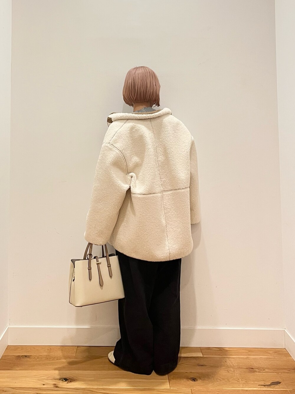 ホワイト系のムートンコート、ベージュ系のスニーカーを着用したレディースの冬コーディネートの4枚目の写真