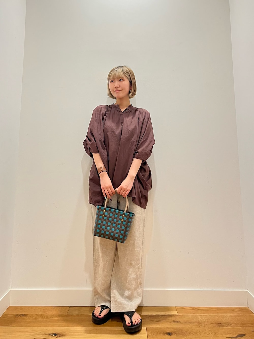 ブラウン系のシャツ/ブラウス、ベージュ系のその他パンツ、ブルー系のネックレスを着用したレディースの夏コーディネートの2枚目の写真