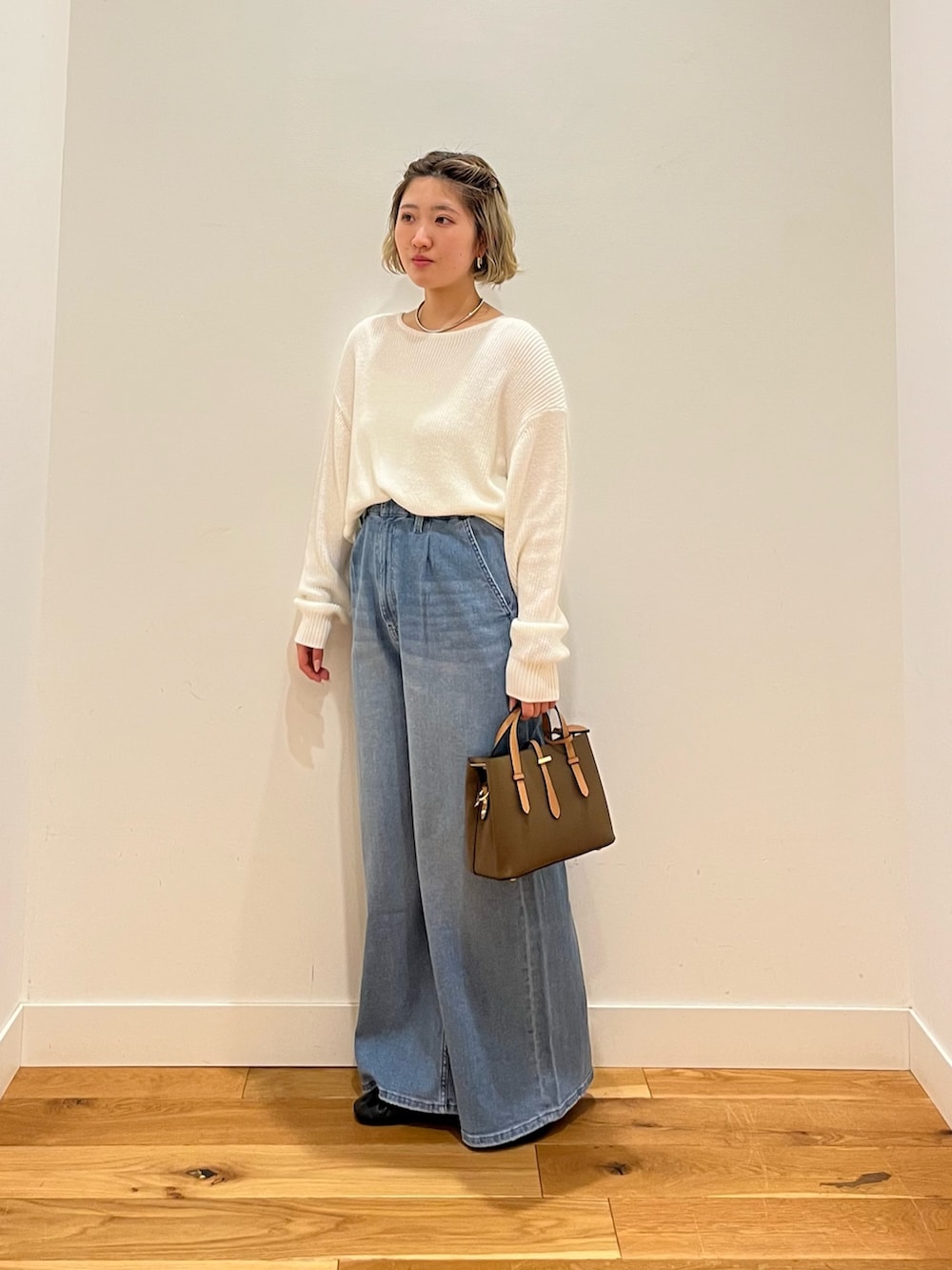 ブルー系のデニムパンツ、ホワイト系のニット/セーターを着用したレディースの春コーディネートの2枚目の写真