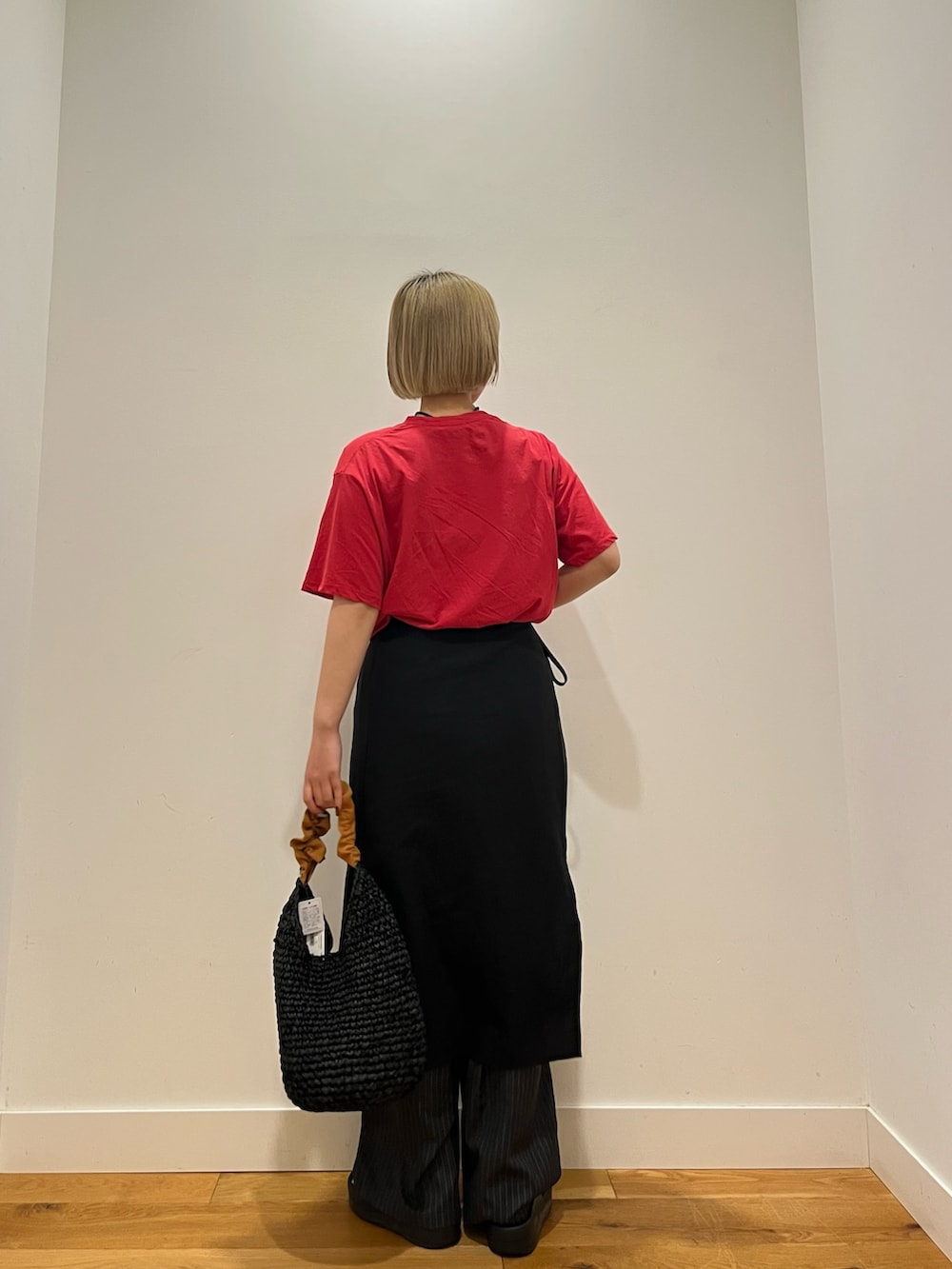 レッド系のTシャツ/カットソー、オレンジ系のかごバッグを着用したレディースの夏コーディネートの4枚目の写真