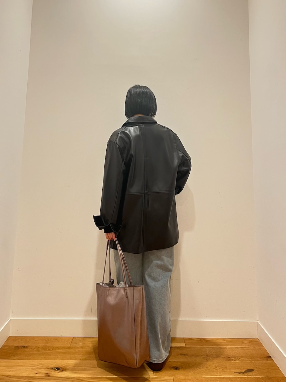 ブラック系のカーディガン/ボレロ、ブラック系のその他アウター、ブルー系のデニムパンツを着用したレディースの秋コーディネートの4枚目の写真