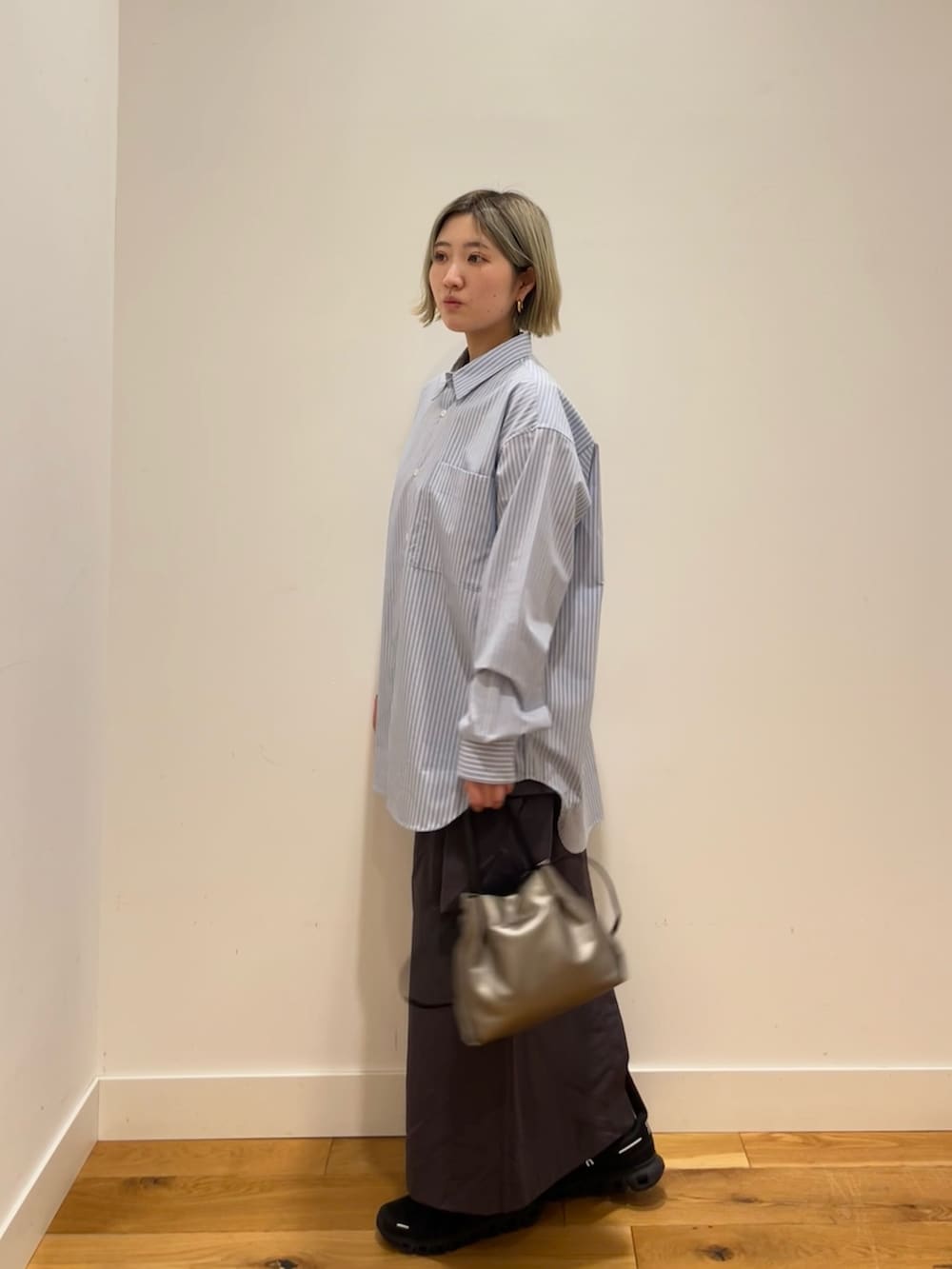 ブルー系のシャツ/ブラウス、グレー系のスカートを着用したレディースの春コーディネートの2枚目の写真