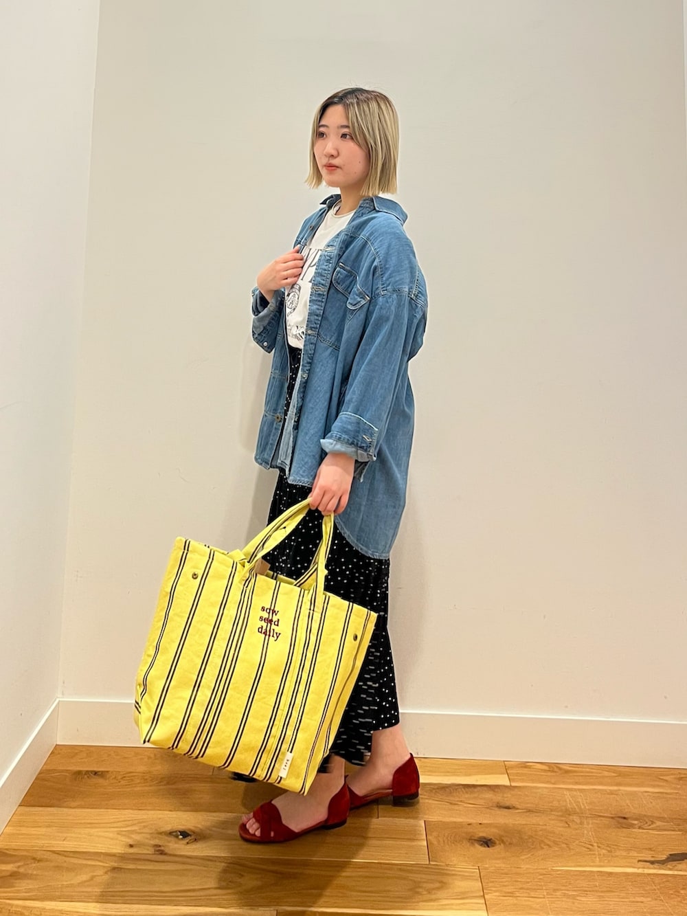 ブラック系のスカート、ブルー系のシャツ/ブラウス、ホワイト系のTシャツ/カットソーを着用したレディースの春コーディネートの2枚目の写真